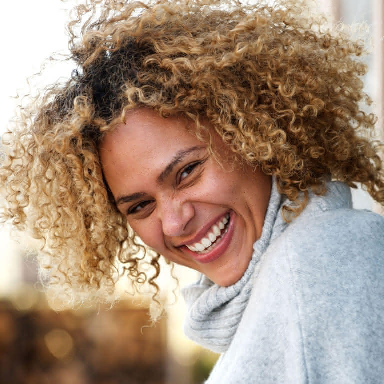 A woman with curly hair smiling